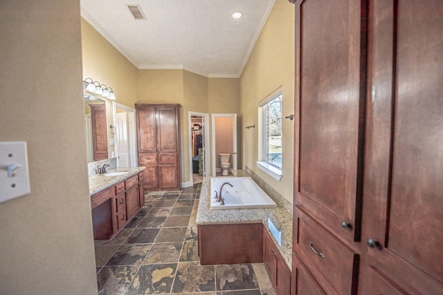 bathroom featuring crown molding, vanity, toilet, and a bathtub