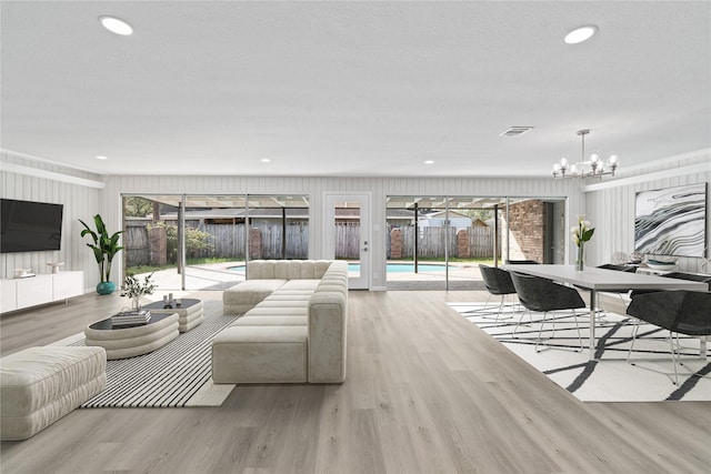 living room featuring an inviting chandelier and light wood-type flooring