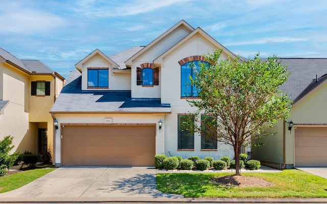 traditional-style house with stucco siding and concrete driveway