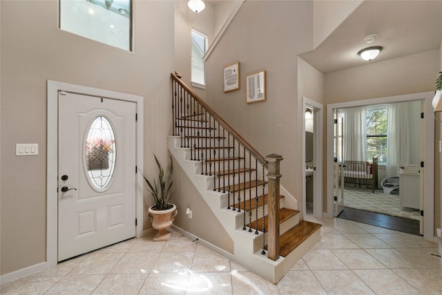 tiled entrance foyer featuring a towering ceiling