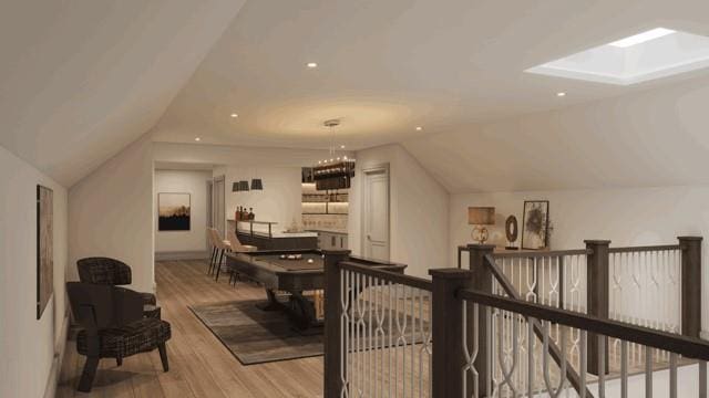 bonus room featuring vaulted ceiling with skylight and light wood-type flooring