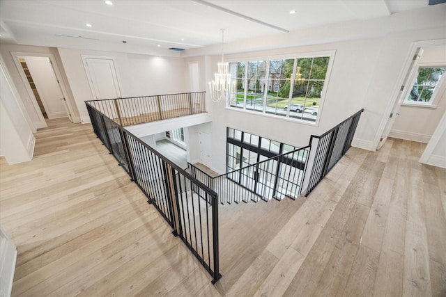 stairway featuring an inviting chandelier and hardwood / wood-style flooring