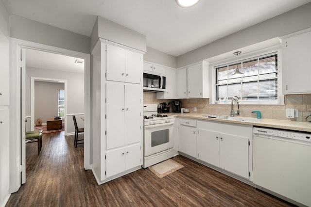 9 Bay Harbor Dr, La Porte, TX 77571 - kitchen with tasteful backsplash, white appliances, sink, and white cabinets