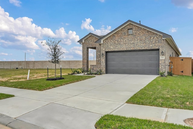 view of front of house featuring brick siding, an attached garage, driveway, and a front yard