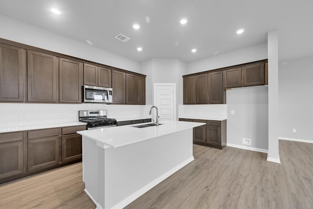 kitchen featuring a sink, visible vents, appliances with stainless steel finishes, and light wood finished floors