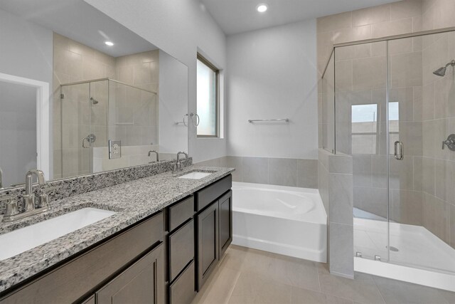 bathroom featuring a garden tub, a stall shower, and a sink