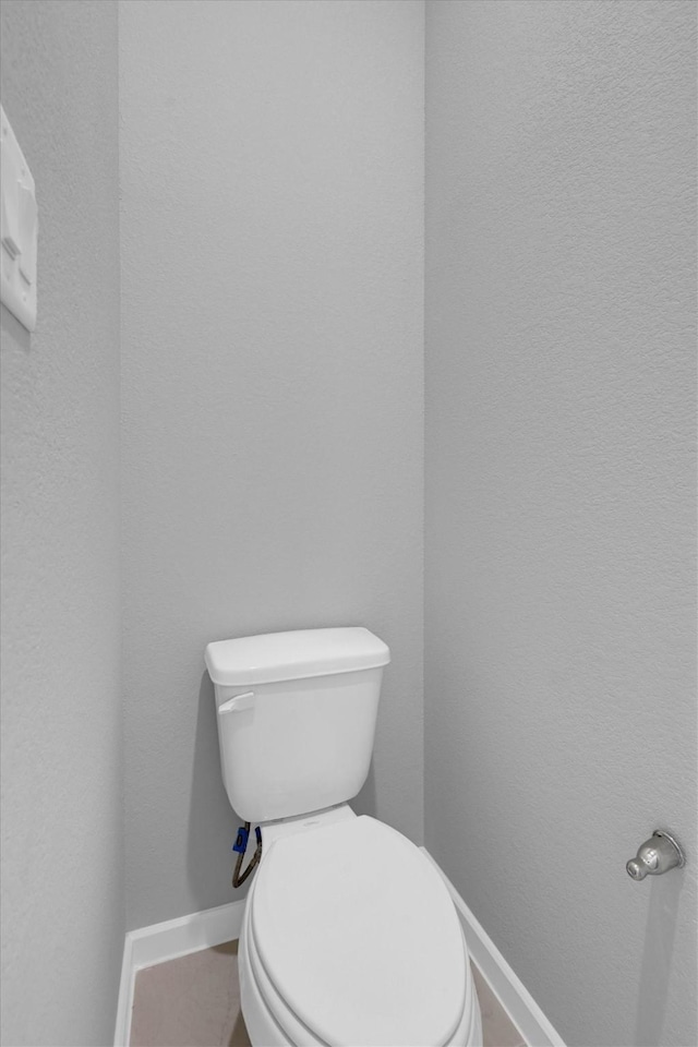 bathroom with toilet and baseboards