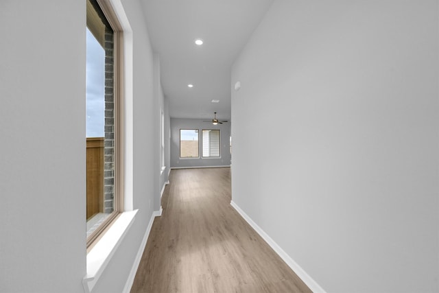 hallway featuring recessed lighting, baseboards, and wood finished floors