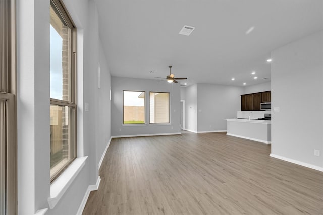 unfurnished living room featuring recessed lighting, baseboards, ceiling fan, and light wood finished floors