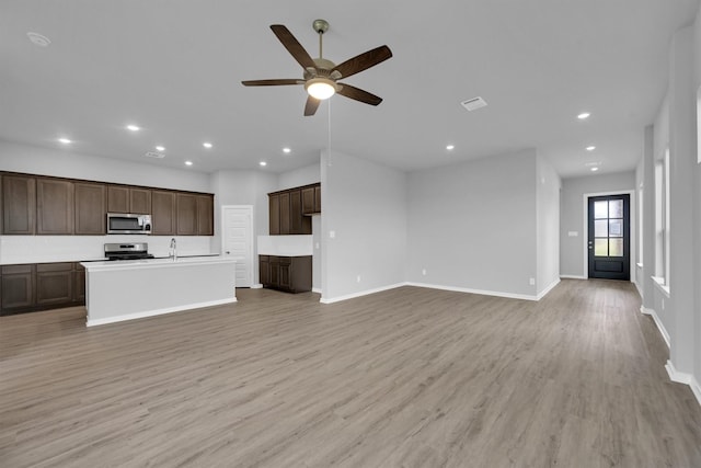 unfurnished living room featuring a ceiling fan, recessed lighting, light wood-type flooring, and baseboards