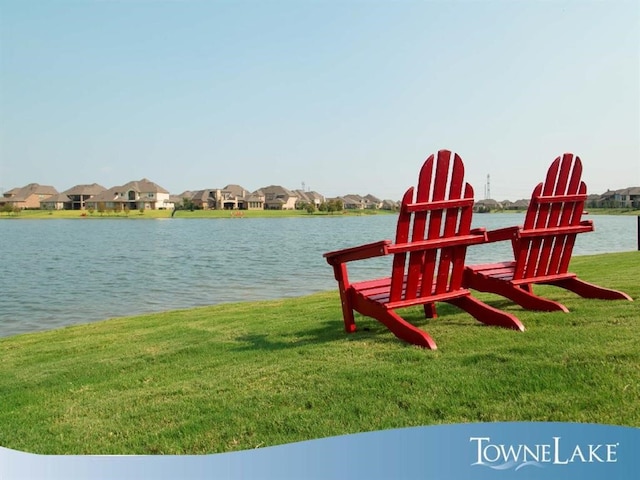 dock area with a water view, a residential view, and a yard