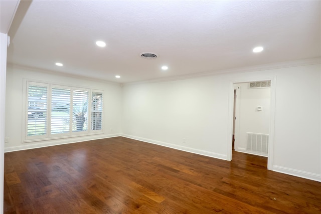 empty room featuring ornamental molding and dark hardwood / wood-style floors