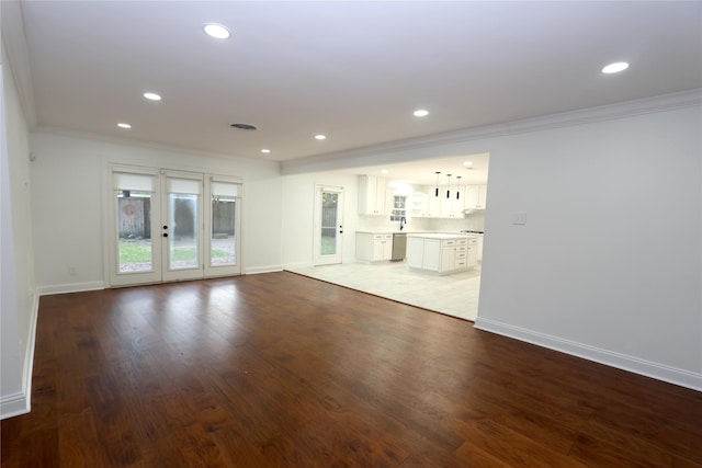 unfurnished living room with dark wood-type flooring and ornamental molding