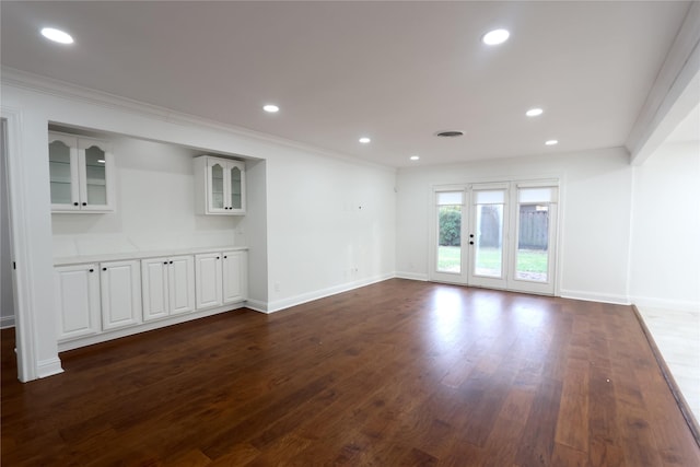 unfurnished living room featuring ornamental molding and dark hardwood / wood-style floors