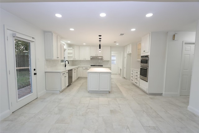 kitchen featuring stainless steel appliances, decorative light fixtures, a center island, and white cabinets