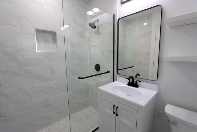 bathroom featuring an enclosed shower, vanity, and toilet