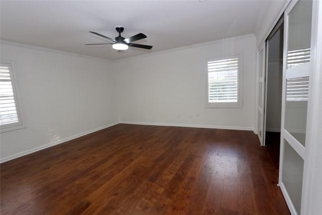 unfurnished bedroom with crown molding, ceiling fan, dark hardwood / wood-style floors, and a closet