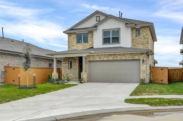 view of front of house with board and batten siding, a front lawn, fence, a garage, and driveway