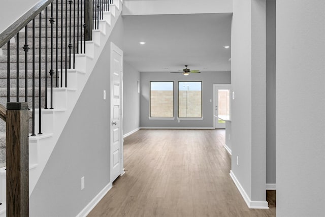 foyer entrance with baseboards, wood finished floors, and stairs