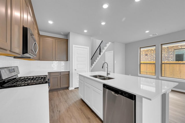 kitchen featuring light wood-type flooring, visible vents, appliances with stainless steel finishes, and a sink