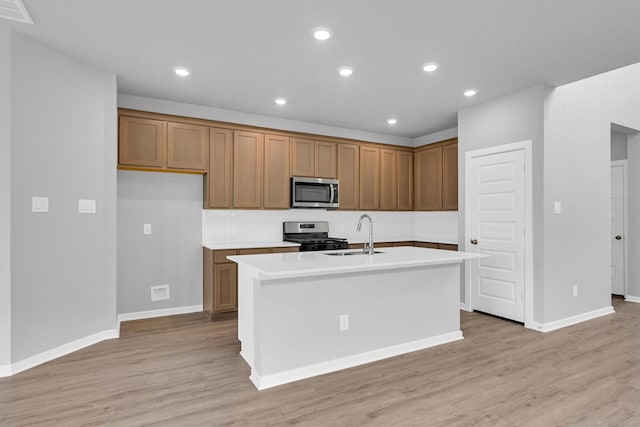 kitchen featuring brown cabinetry, visible vents, stainless steel appliances, and a sink