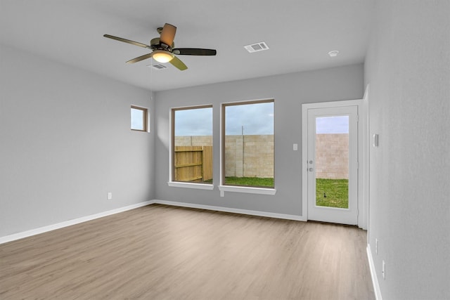 spare room featuring visible vents, baseboards, and wood finished floors