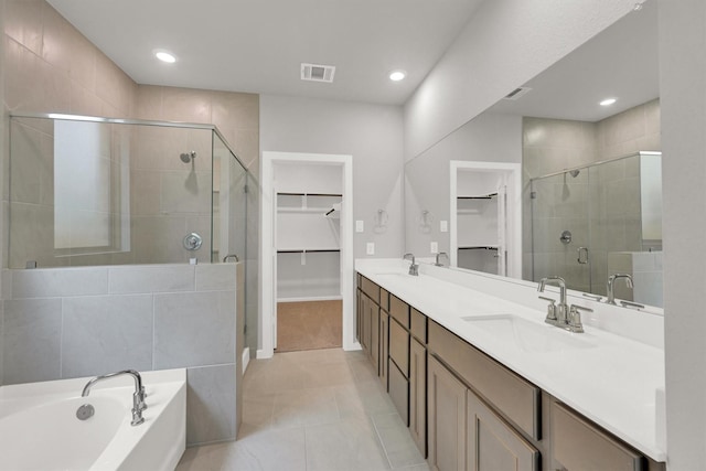 full bath with a spacious closet, visible vents, a shower stall, and a sink