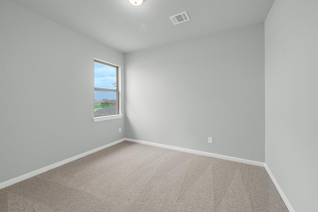 empty room with visible vents, carpet floors, and baseboards