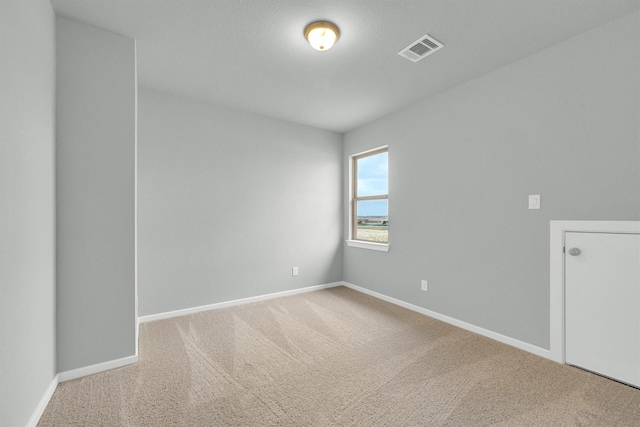 carpeted spare room with baseboards and visible vents