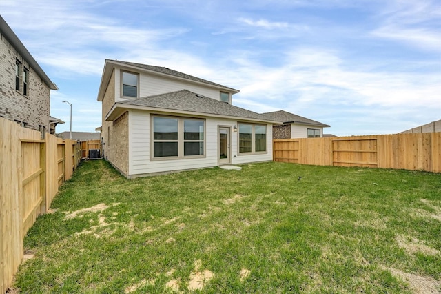 back of house featuring a lawn, central AC, a fenced backyard, and a shingled roof