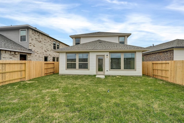 rear view of house with a lawn, a fenced backyard, and roof with shingles