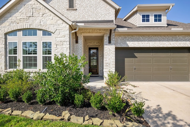 view of front of house featuring driveway, stone siding, a shingled roof, and brick siding