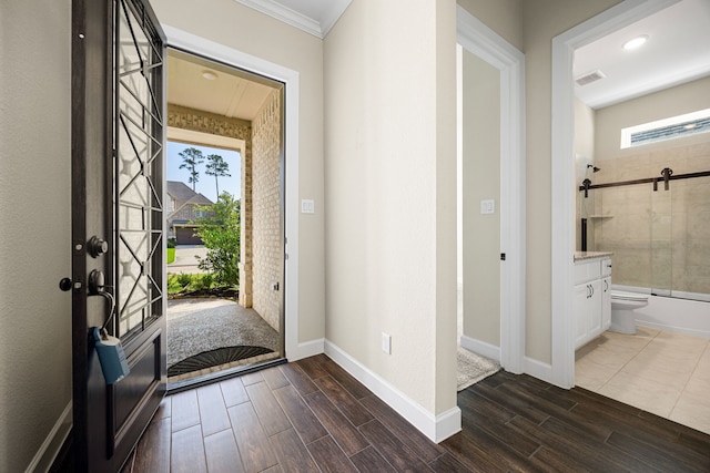 foyer entrance with wood finish floors, a healthy amount of sunlight, and visible vents