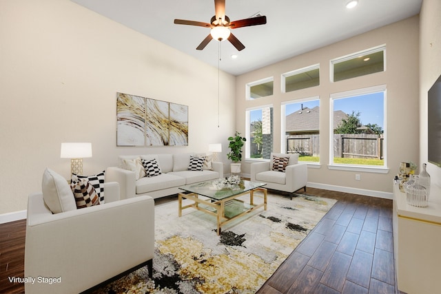 living room with dark wood-style floors, ceiling fan, and baseboards