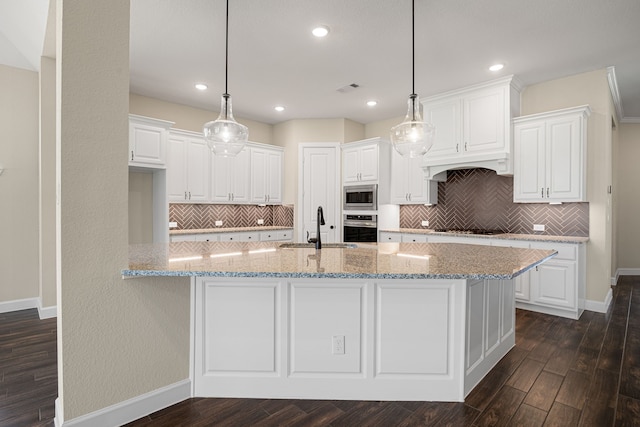 kitchen with appliances with stainless steel finishes, white cabinetry, a sink, and dark wood-style floors