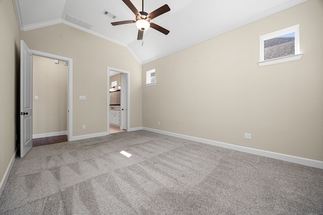 unfurnished bedroom featuring vaulted ceiling, ornamental molding, light carpet, and visible vents