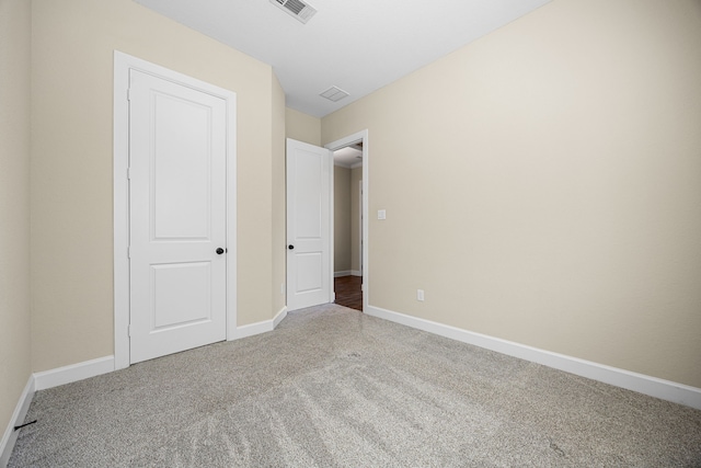 unfurnished bedroom with carpet flooring, visible vents, and baseboards