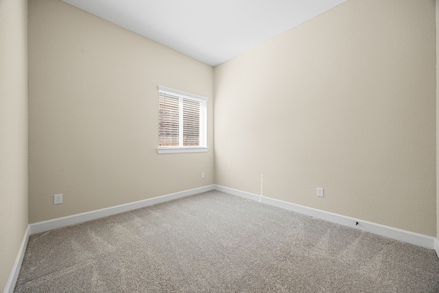 empty room featuring carpet floors and baseboards