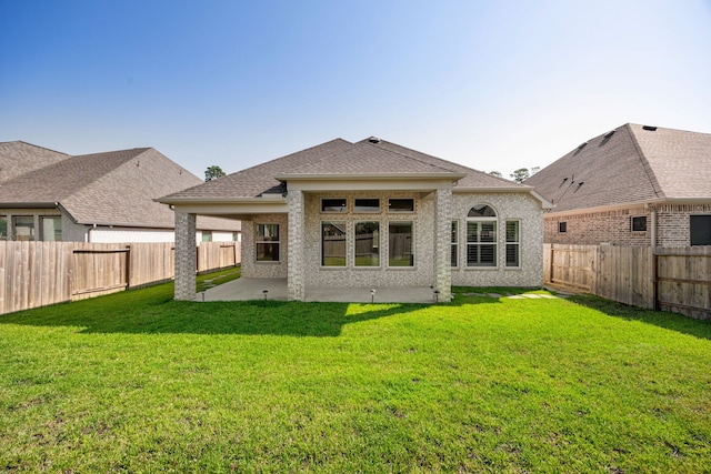 back of property featuring a patio, a shingled roof, a lawn, and a fenced backyard