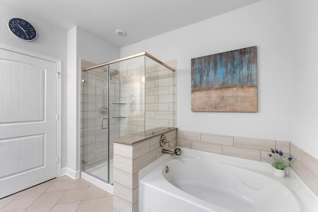 bathroom featuring a stall shower, tile patterned floors, and a bath