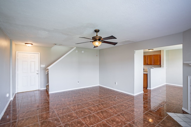 unfurnished living room featuring a textured ceiling and ceiling fan