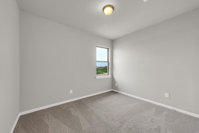 carpeted spare room with baseboards