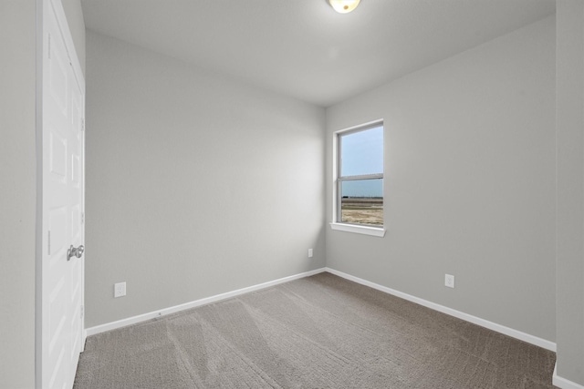 carpeted spare room featuring baseboards