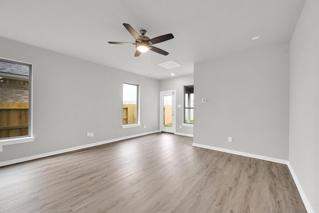 spare room featuring visible vents, baseboards, wood finished floors, and a ceiling fan