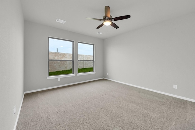 empty room with carpet flooring, baseboards, and visible vents