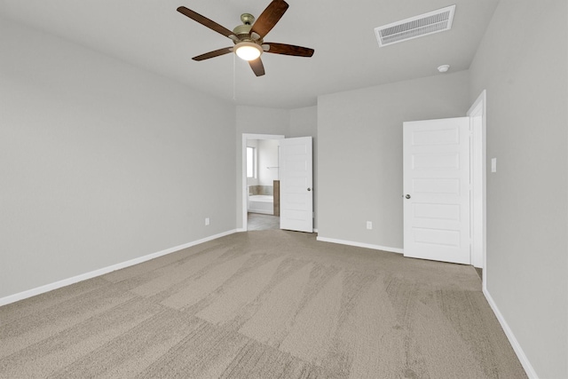 unfurnished bedroom featuring visible vents, baseboards, ceiling fan, carpet flooring, and ensuite bath