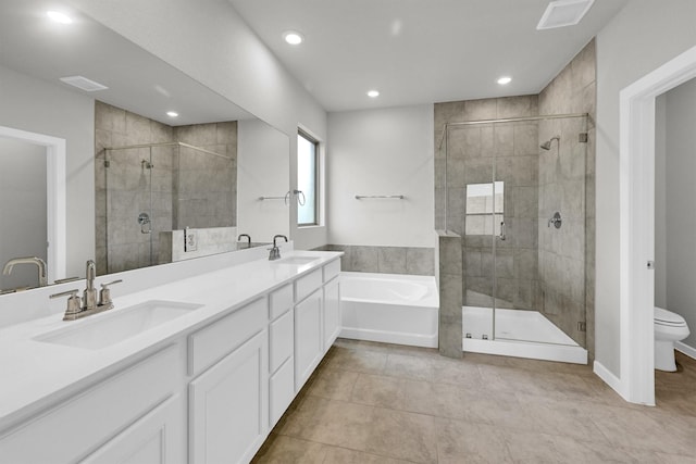 bathroom with a stall shower, toilet, a garden tub, and a sink