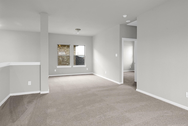 unfurnished room featuring baseboards and carpet