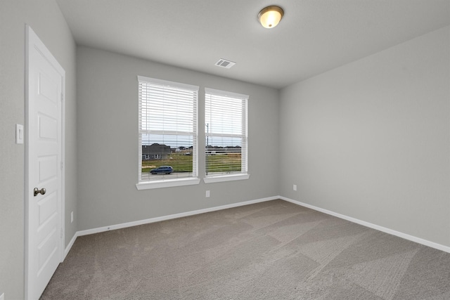 spare room featuring visible vents, baseboards, and carpet flooring