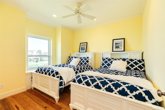 bedroom featuring ornamental molding, hardwood / wood-style floors, and ceiling fan